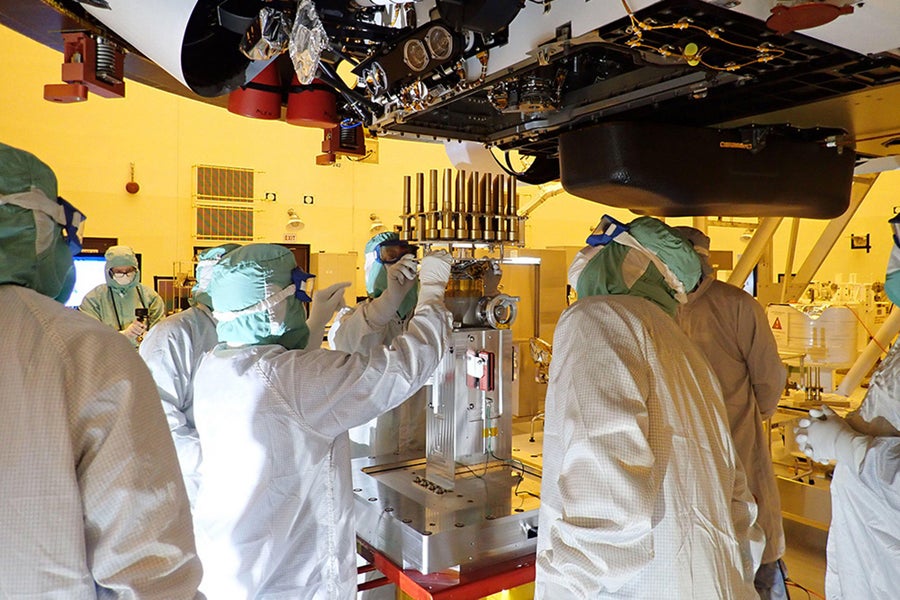 Engineers and technicians insert 39 sample tubes into the belly of the Perseverance rover in this pre-launch photo from May 20, 2020. Cost overruns and schedule delays on the MSR project have heightened uncertainties over how—and if—Perseverance's samples will be brought back to Earth.
