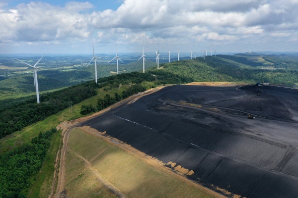 Aerial view of turbines in landscape behind a coal processing field