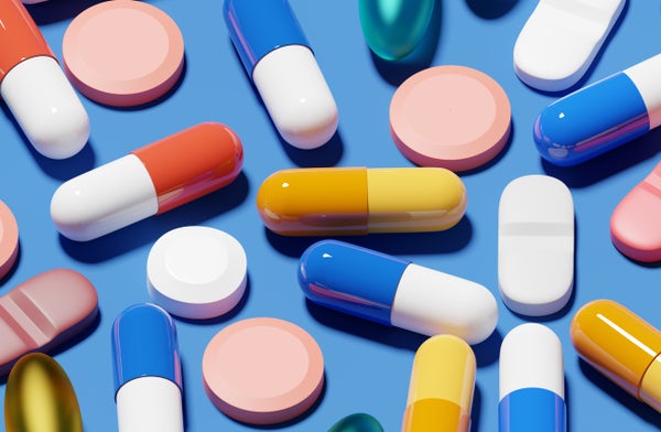 Various pills in many colors on a blue background.