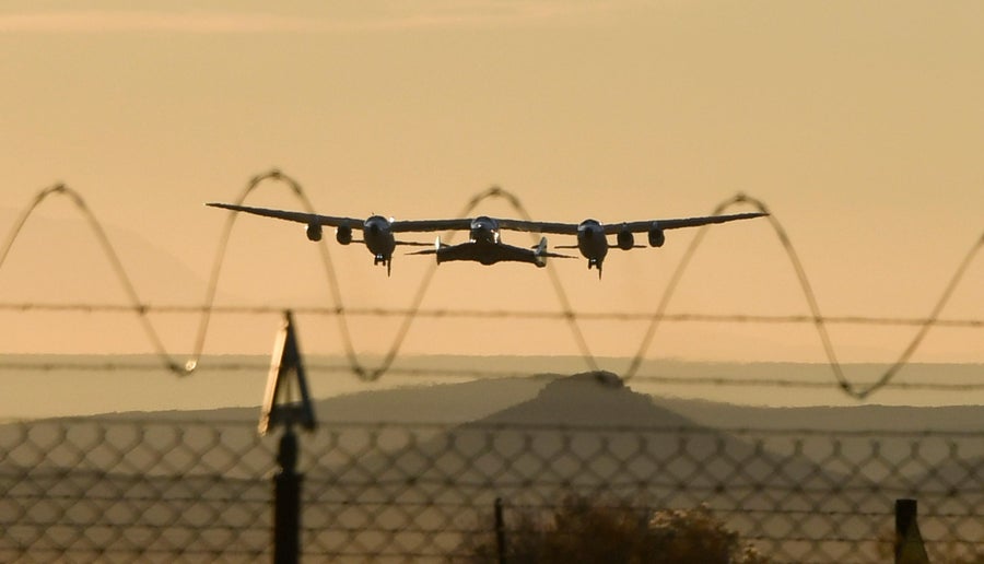 Virgin Galactic SpaceShipTwo takes off in the Mojave Desert, California, seen behind barbed wire fencing